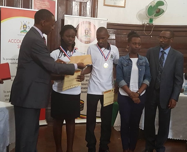 Mr. Luyombu Abbasi and Ms. Awino Mercy receiving an award.