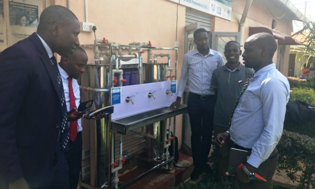 RAN Officials (Left) join KCCA Officials at the hand over of an Eco-water Purifier System (Centre) on 14th May 2018, KCCA Health Center IV, Kisenyi, Kampala Uganda. Image:RAN