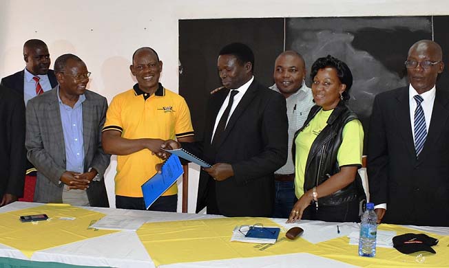 The Vice Chancellor-Prof. Barnabas Nawangwe (3rd L) exchanges the signed MoU with NFC Principal-Mr. Godfrey Akubonabona (4th L) as Mr. Henry Mwebe (L), Prof. Bernard Bashaasha (2nd L), Dr. Gorettie Nabanoga (2nd R), Prof. Mnason Tweheyo (3rd R) and other officials witness during the visit to NFC on 15th August 2018, Masindi Uganda