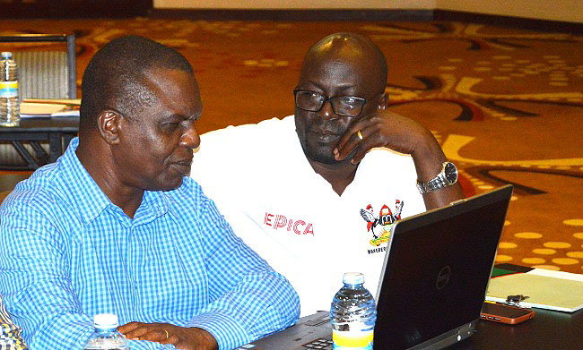 Assoc. Prof. Paul Birevu Muyinda (R) and Assoc. Prof. Gilbert Maiga (L) consult during a retret to review Graduate Training policies and guidelines on 25th May 2018.