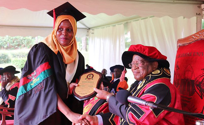 The Chancellor, Prof. Ezra Suruma (Right) hands over the Convocation Award to MUBS’ Ms. Namuwaya Hajarah Ali; the Best Humanities and Best Overall Student of the 69th Graduation Ceremony, Makerere University. Ms. Namuwaya attained a CGPA of 4.94 in the Bachelor of Business Computing.