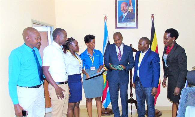 The Minister of ICT & National Guidance-Hon. Frank Tumwebaze (3rd R) admires the plaque won by Akorion's Ezyagric Innovation Team during the interaction at his office on 20th November 2018. Right is RAN's Harriet Adong while 2nd Right is Akorion CEO-Mr. William Luyinda