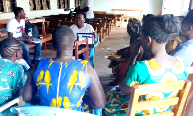 A group of women in Gulu trying to understand from a facilitator how web systems can help them report cases of violence. Left is Tumusiime Martin, a Computer Science student at Makerere University, RAN Innovator and Team Leader for Tuyambe Ba Maama 2018.