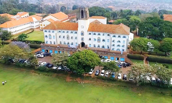 An aerial photo of the Main Building and Freedom Square (foreground) with the College of Humanities and Social Sciences (CHUSS)-Left, Makerere University, Kampala Uganda