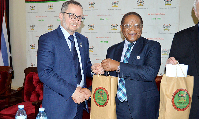 The Chancellor, Prof. Ezra Suruma (Right) hands over an assortment of Mak publications to Mr. Arthur Stark, Chairman of the Conference of Presidents of Major American Jewish Organizations (Left) during the delegation's visit to Makerere University, Kampala Uganda on 14th February 2019.