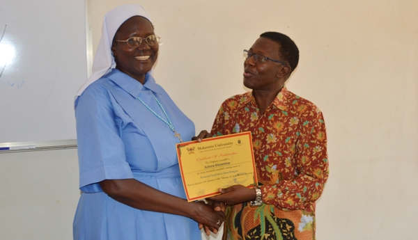 The Director DRGT-Prof. Buyinza Mukadasi (Right) hands over a certificate to Sr. Achora Vincentina; a PhD Student who took part in the Qualitative Data Analysis Training on 8th February 2019 at Makerere University, Kampala Uganda.