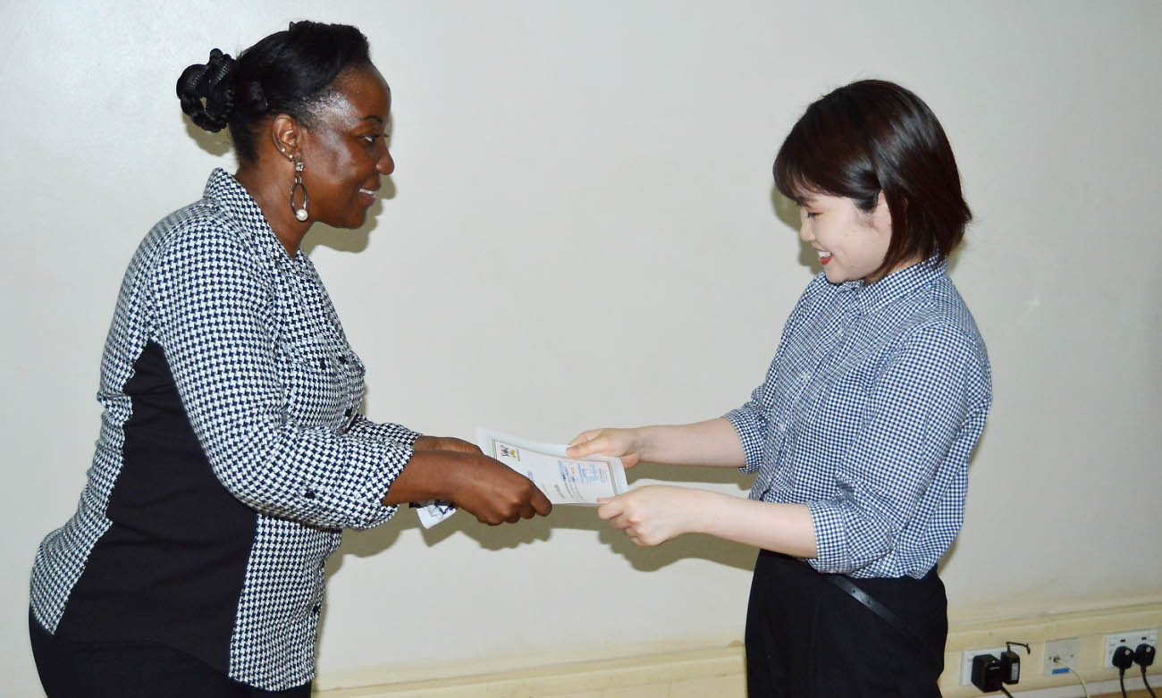 The Deputy Principal CAES, Assoc. Prof. Gorreti Nabanoga (Left) hands over a certificate to one of the 15 students from Tottori University Japan that completed the three-week Practical Education Program in Uganda, 21st March 2019, CEDAT, Makerere University, Kampala.
