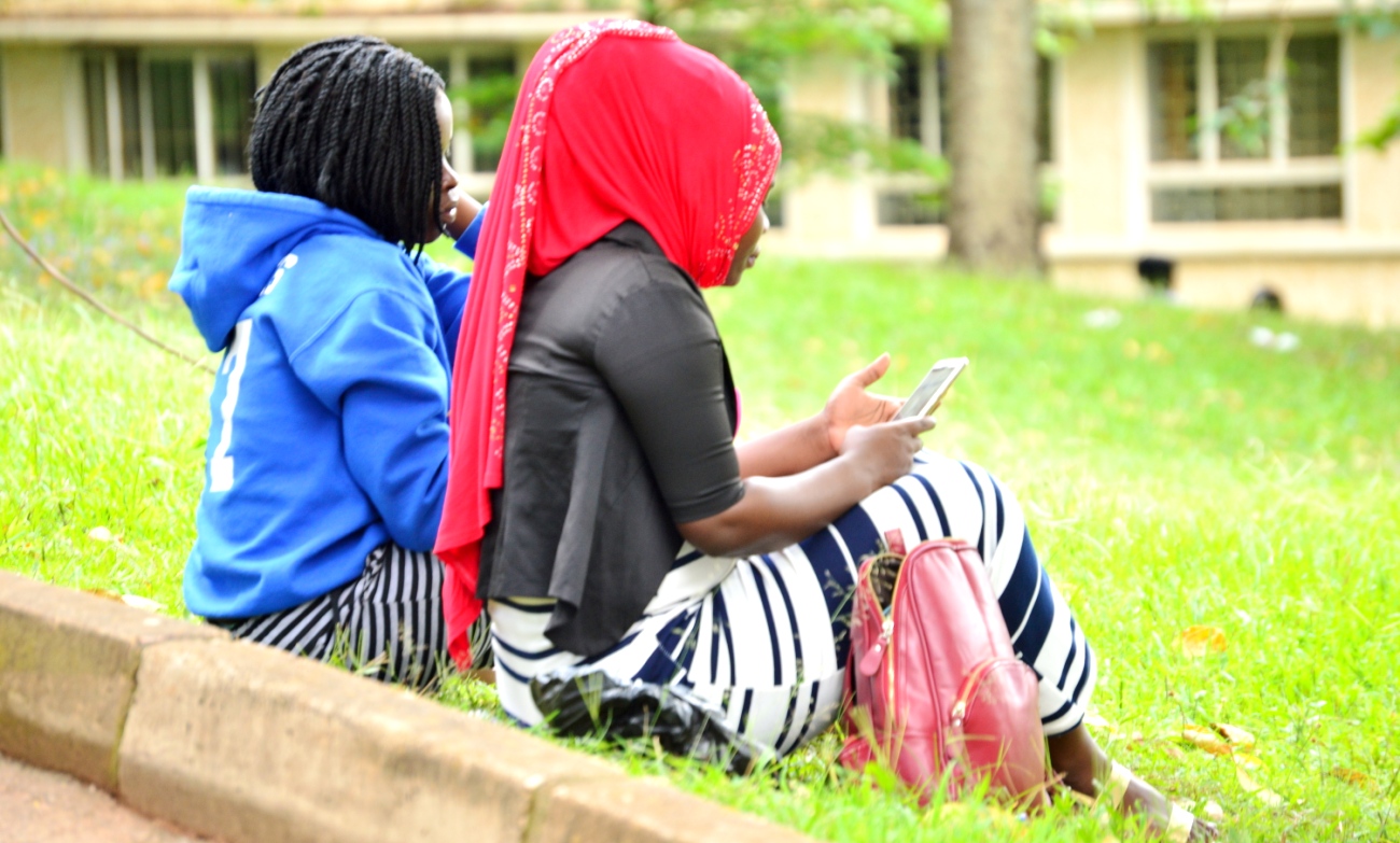 Female Students access one of the wireless hotspots along the Edge Road, near the College of Humanities and Social Sciences (CHUSS), Makerere University, Kampala Uganda