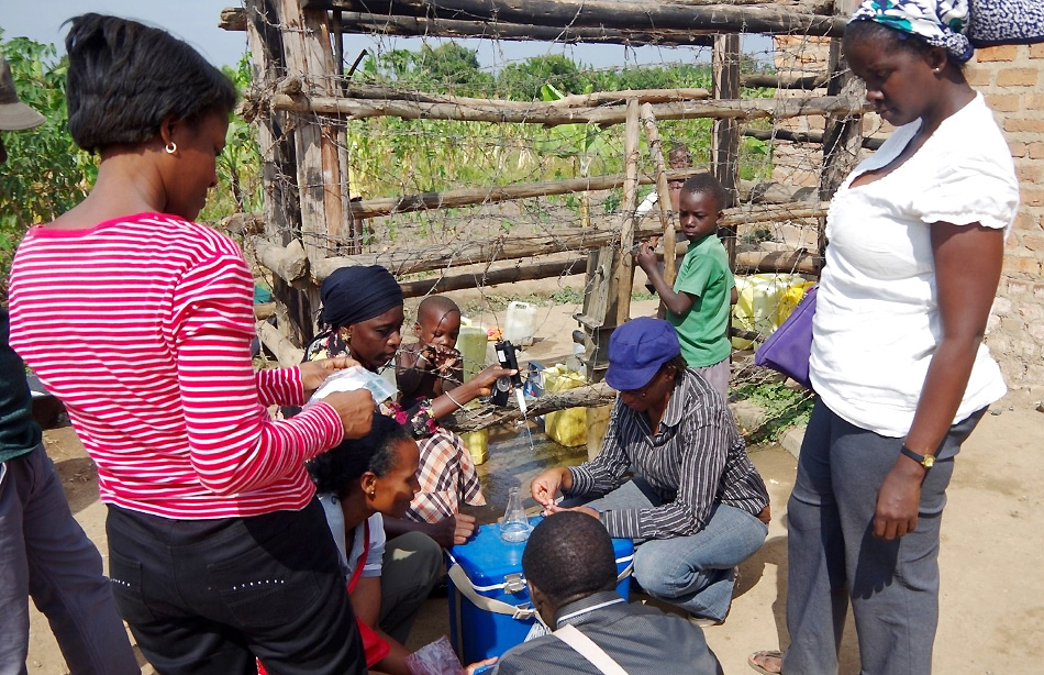 Researchers from AfriWatSan consortium testing the quality of water from a shallow well in Lukaya Town, Uganda. Image:Royal Society