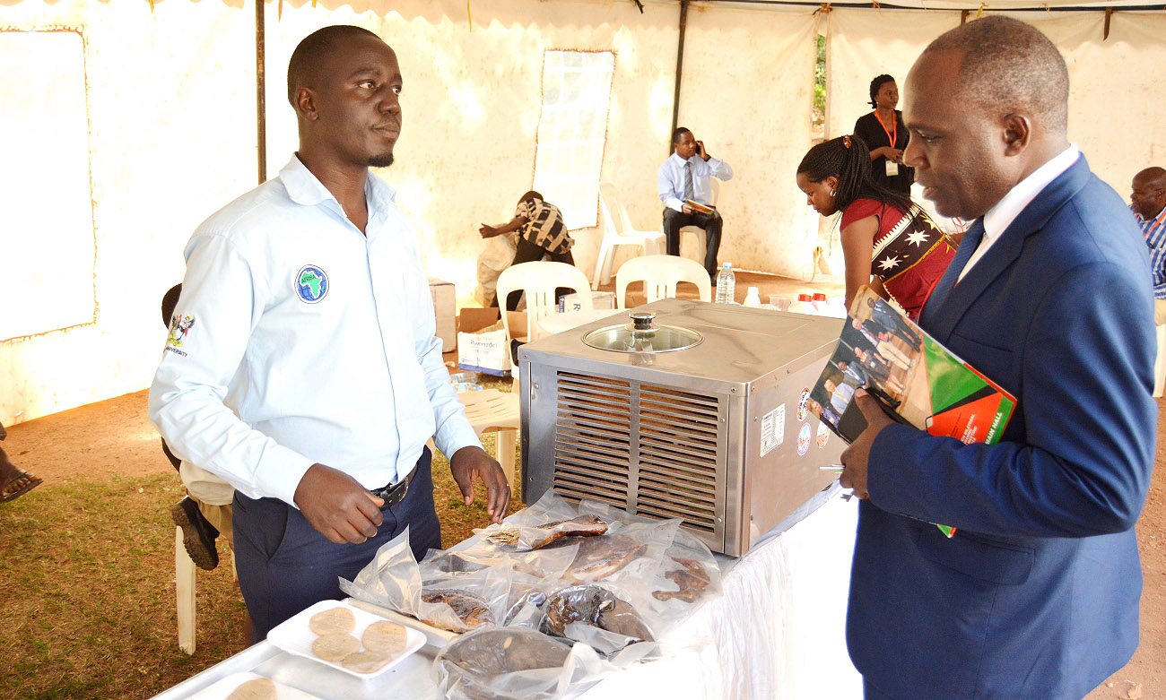Dr. John Mango Magero, Team Leader, Sida Math sub-programme (Right) visits the AFRISA exhibition showcasing various products and methods of meat preservation as part of the Mak-Sida Annual Planning Meeting, 8th April 2019, Makerere University, Kampala Uganda
