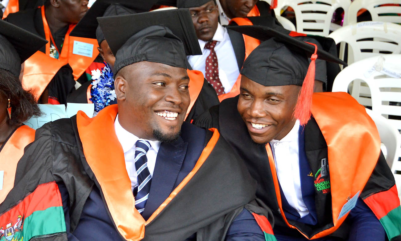 The 83rd Guild President H.E. Kato Paul (Right) shares a light moment with a fellow graduand from the College of Education and External Studies (CEES) during the first session of the 69th Graduation on 15th January 2019, Freedom Square, Makerere University, Kampala Uganda. H.E. Kato graduated with a BA Education.