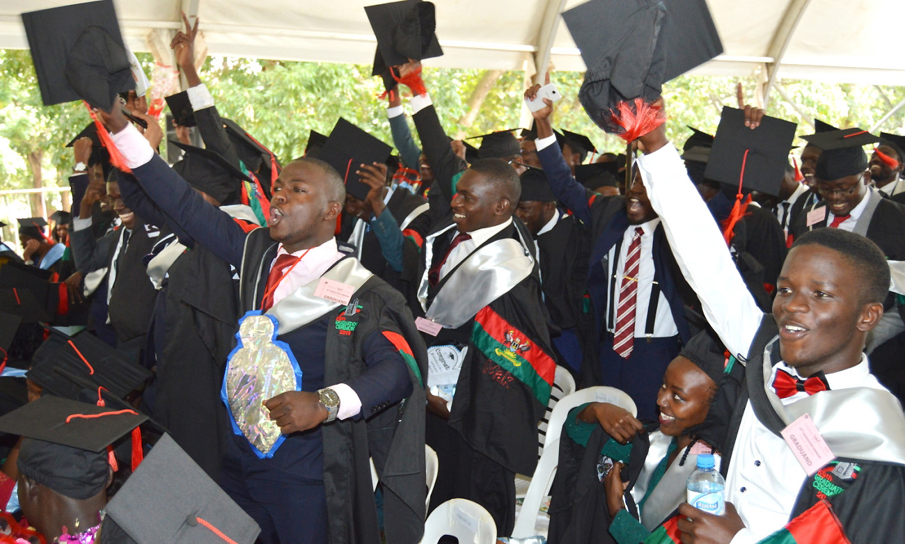 Esctatic male students raise their caps on Day4 of the 69th Graduation Ceremony, 18th January 2019, Freedom Square, Makerere University, Kampala Uganda