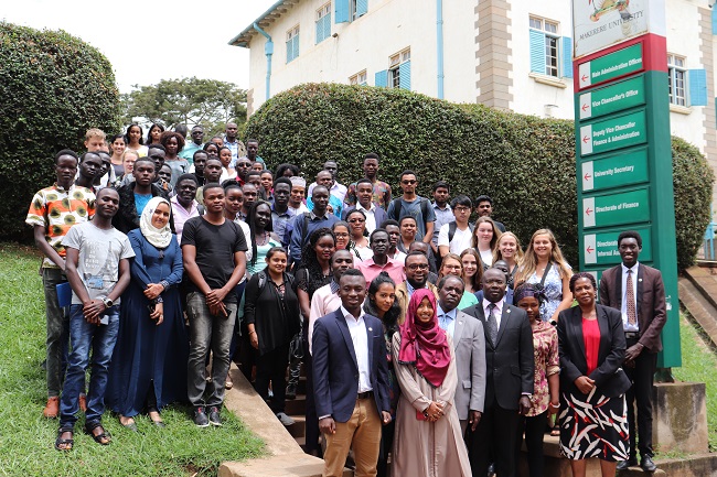 The Acting Deputy Vice Chancellor for Finance and Administration Prof. William Bazeyo together with the Acting Manager for Communication and International Relations Dr. Muhammad Kiggundu Musoke and the Senior Administrative Assistant (International Relations), Ms Martha Muwanguzi posing for a photo with international students after the orientation meeting.