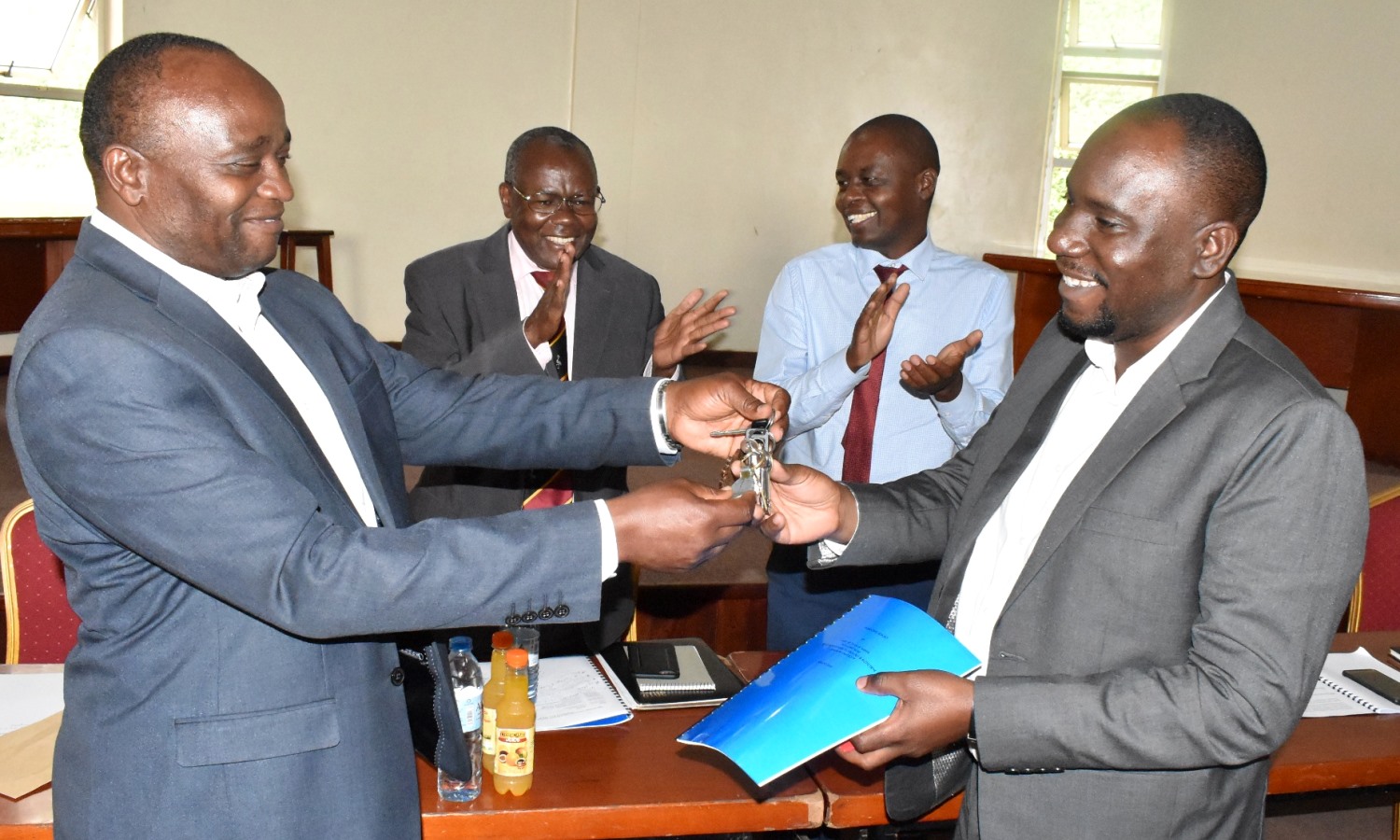 Outgoing Head FTHN, Prof. Archileo Kaaya (Left) hands over keys to the office to New Head, Dr. Ivan Muzira Mukisa (Right) as the Principal CAES-Prof. Bernard Bashaasha (2nd Left) and Dean SFTNB-Dr. Abel Atukwase (2nd Right) applaud on 19th August 2019, Conference Hall, SFTNB, CAES, Makerere University, Kampala Uganda.