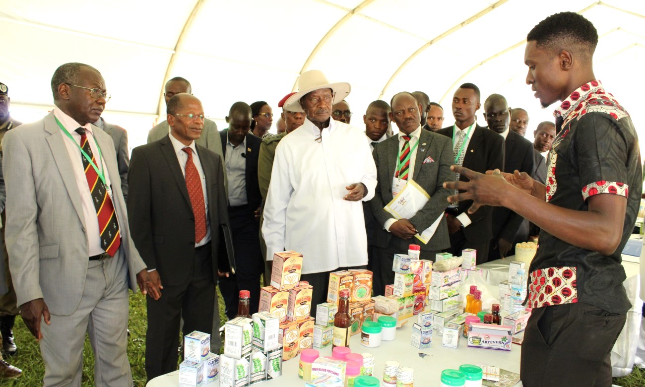 H.E. President Yoweri Kaguta Museveni (with hat) interacts with one of the student exhibitors at the Agricultural Day and Exhibition held at the Freedom Square on 25th September 2019. Extreme Left is Prof. Bernard Bashaasha, Principal, College of Agricultural and Environmental Sciences (CAES) and Hon. Dr. John Chrysostom Muyingo, Minister of State for Higher Education (Second Left).