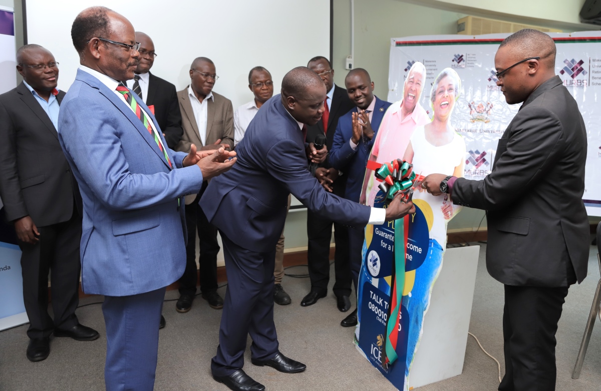 The Vice Chairperson of Council, Rt. Hon. Daniel Fred Kidega cuts the tape to signify the official launch of the MURBS Annuity Arrangement with ICEA Life Company as the Vice Chancellor, Prof. Barnabas Nawangwe and other officials applaud on 11th October 2019, Makerere University, Kampala Uganda
