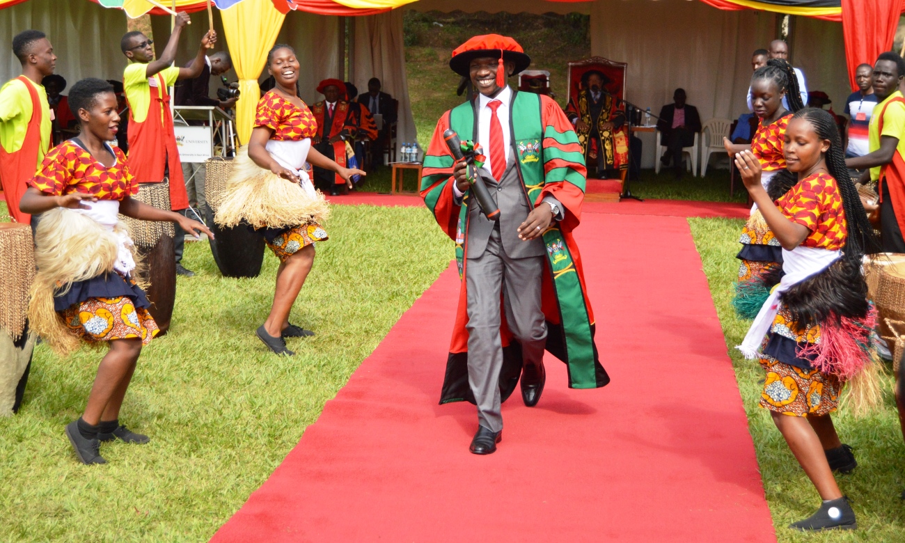 A Male PhD Graduand from MUBS strides down the red carpet shortly after being conferred upon his award on Day 3 of the 69th Graduation Ceremony, 17th January 2019, Freedom Square, Makerere University, Kampala Uganda