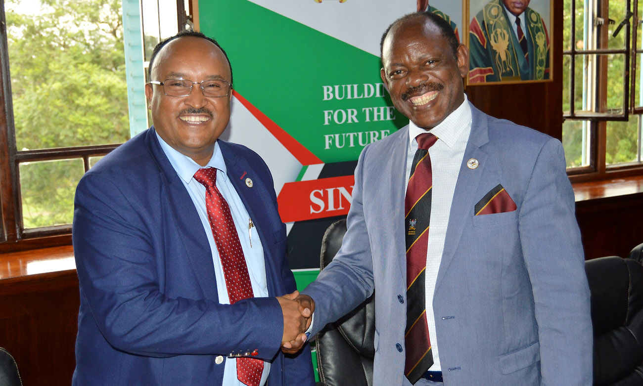 The Vice Chancellor-Prof. Barnabas Nawangwe (Right) shakes hands with Hon. Tesfaye Daba (Left) after pinning the Mak Badge on the Head of Delegation's lapel on 27th November 2019, Makerere University, Kampala Uganda.