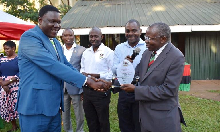 The Principal, CAES-Prof. Bernard Bashaasha (Right) hands over a plaque to Mr. Obura Edward left in recognition of his distinguished service as College Registrar on 13th December 2019, School of Forestry Gardens, CAES, Makerere University, Kampala Uganda.