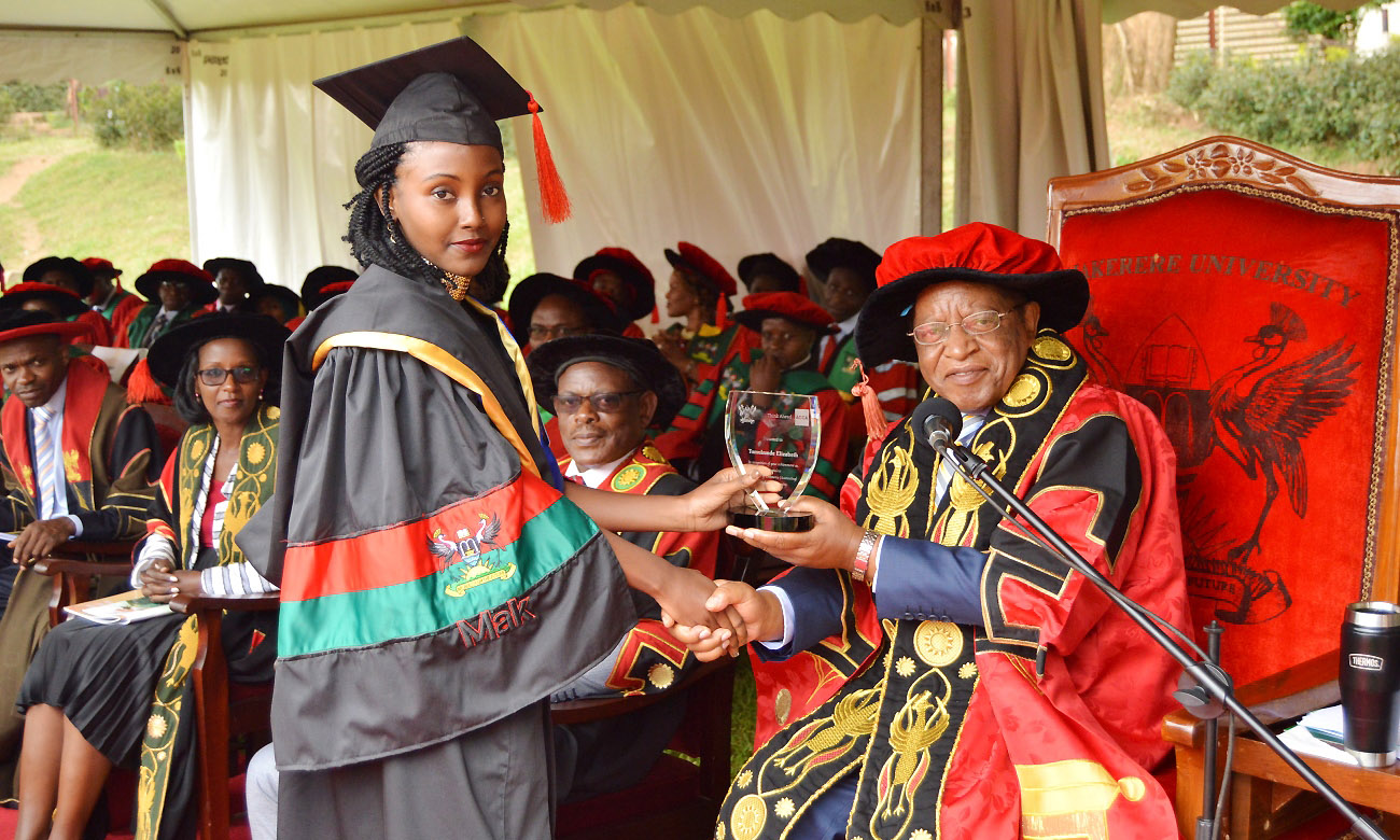 The Chancellor, Prof. Ezra Suruma (Right) hands over the ACCA Uganda Award to Ms. Tumukunde Elizabeth, the best performing student in Bachelor of Commerce (Accounting Option) during the 2nd Session of the 69th Graduation Ceremony on 16th January 2019 at Makerere University, Kampala Uganda
