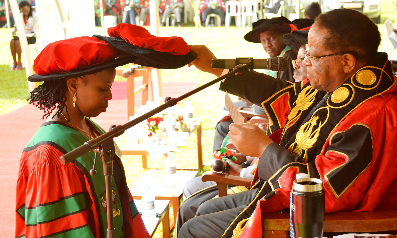 The Chancellor-Prof. Ezra Suruma (Right) confers a PhD upon CoNAS' Ms. Uwimbabazi Moreen during Day 1 of the 70th Graduation Ceremony, 14th January 2020, Makerere University, Kampala Uganda.