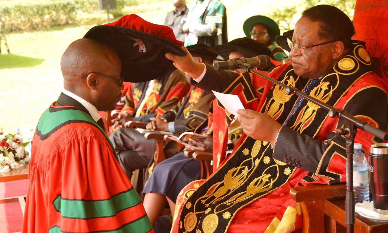 The Chancellor-Prof. Ezra Suruma (Right) confers a PhD upon the School of Law's Mr. TUSASIRWE Benson during Day 4 of the 70th Graduation Ceremony, 17th January 2020, Makerere University, Kampala Uganda.