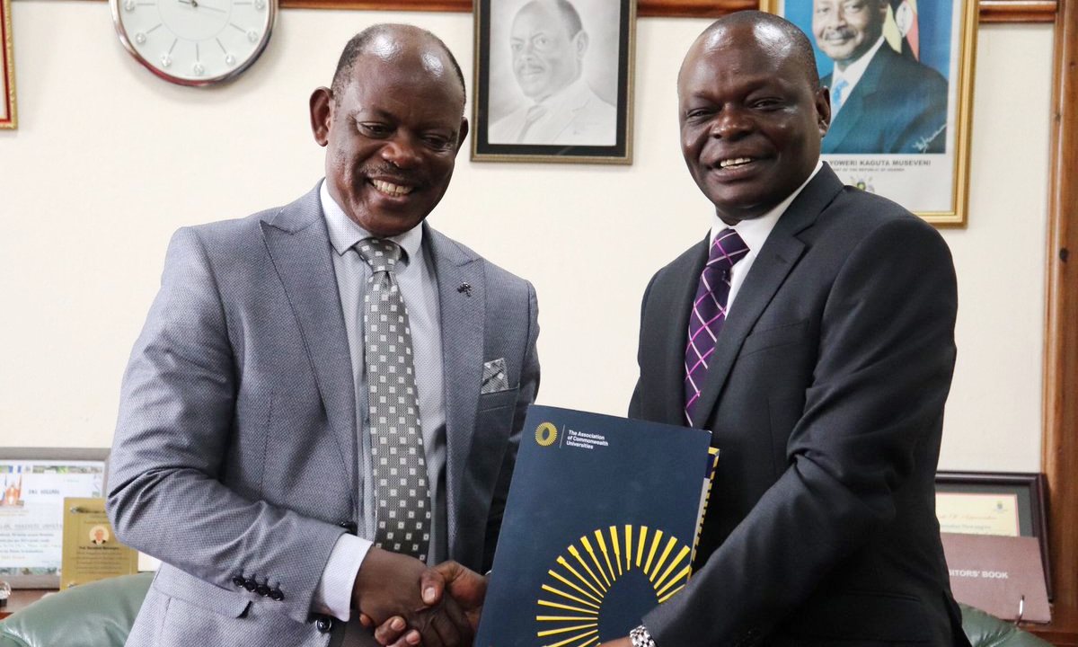 The Vice Chancellor-Prof. Barnabas Nawangwe (Left) receives some reading materials from the ACU's Mr. George Ananga during their meeting on 15th December 2019, Makerere University, Kampala Uganda.