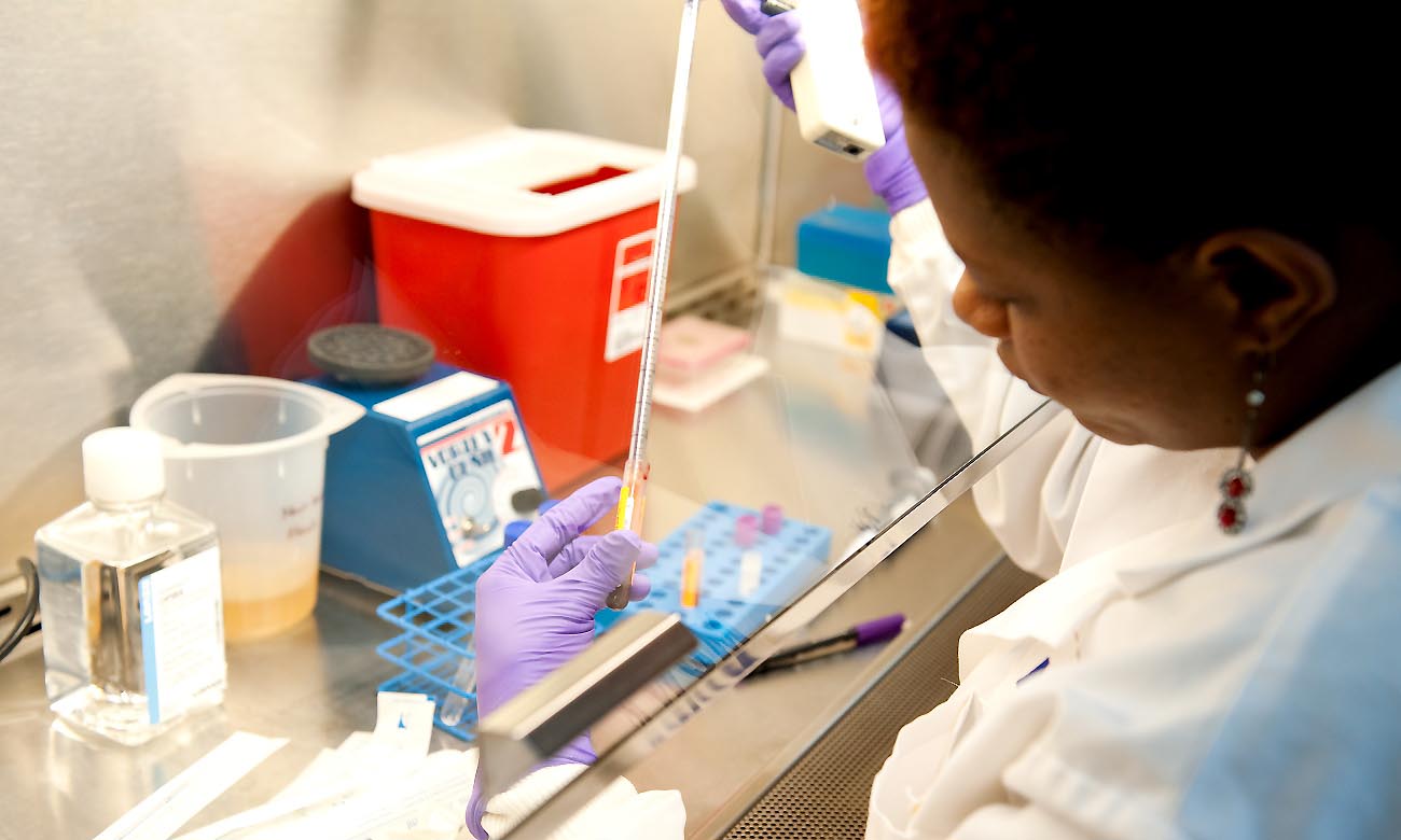 Handling of samples behind a protective glass screen in one of the state-of-the-art Labs at the College of Health Sciences, Mulago Campus, Makerere University, Kampala Uganda. Date taken: 13th August 2010.