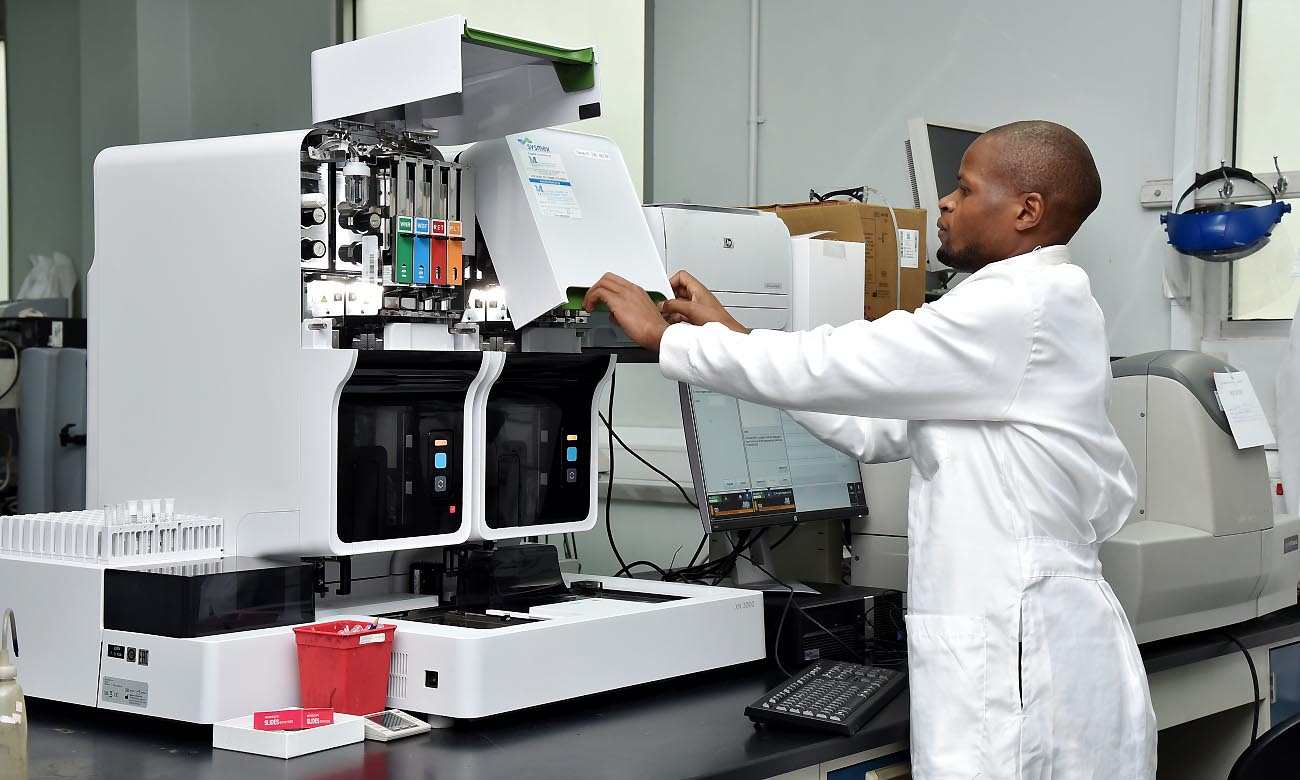 A Member of Staff prepares to use the XN-2000 Hematology Analyzer in the Infectious Diseases Institute (IDI) Core Lab, Mulago Campus, Makerere University, Kampala Uganda. Date taken: 13th February 2020. The XN-2000 is capable of processing 200 blood samples per hour.