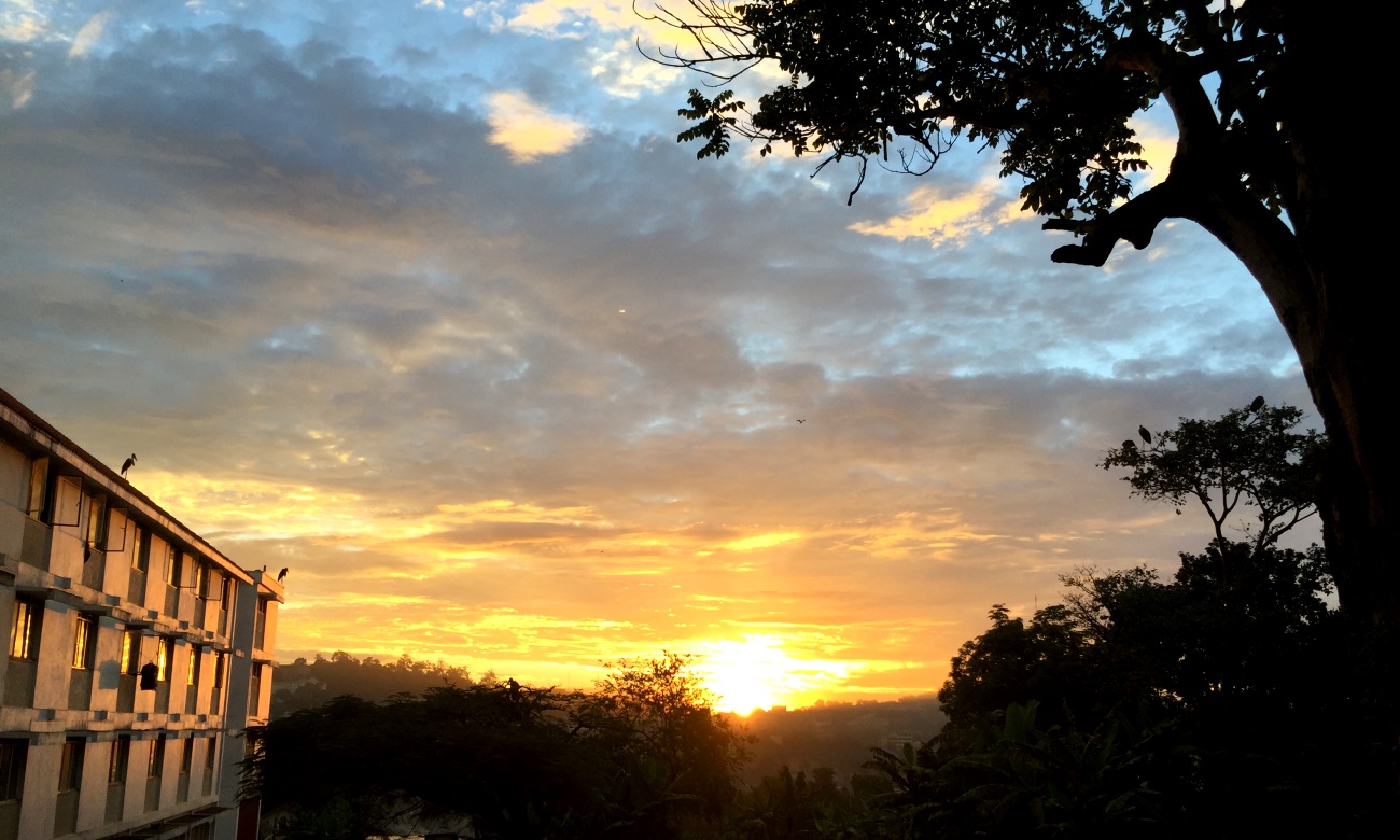 The sun casts a golden hue on Nkurmah Hall (Left) as it rises over Mulago and Kololo hills as seen from Makerere University, Kampala Uganda. Date taken: 20th April 2015.