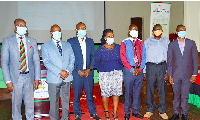 Vice Chancellor Prof. Barnabas Nawangwe (Extreme Left) and First Deputy Vice Chancellor Dr. Umar Kakumba (Extreme Right) join Principal Investigator Prof. Joseph YT Mugisha (Second Left) and the research team in a group photo at the Press Conference held at Main Hall on 16th June 2020.