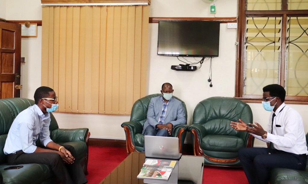 The Vice Chancellor-Prof. Barnabas Nawangwe (Centre) witnesses a demonstration of the "COVID Can I Do It?" Platform by Medical Students-Mpaju David (Left) and Byamugisha Joseph (Right) in his office on 20th May 2020, Makerere University, Kampala Uganda.