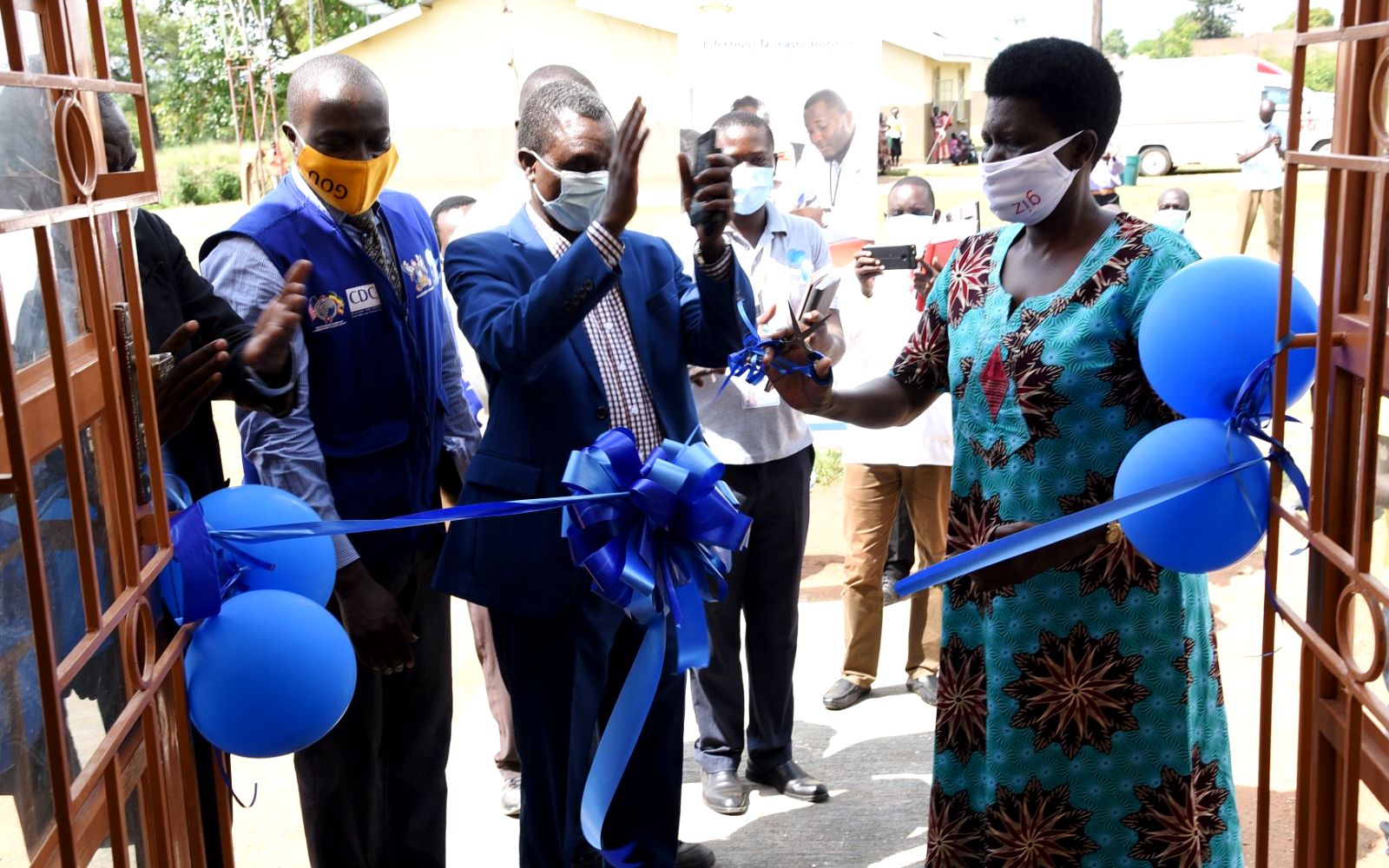 The Deputy RDC Arua, Akello Alice Opio (Right) cuts the tape to unveil the newly renovated ART Clinic at Okollo Health Centre III as the Project Manager-Dr. Twaha Mahaba (Left) and other officials witness on 14th August 2020, Madi-Okolo, Arua District, Uganda. Photo credit: IDI