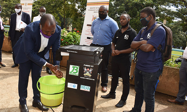 Patrick J. Mugisha (Left)  the Assistant Commissioner, Innovations and Intellectual Property Management - Ministry of Science, Technology, and Innovation wash hands after launching the TW-20 Handwashing Machine