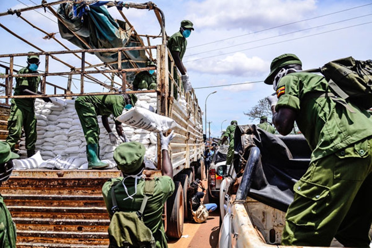 LDU personnel offload bags of relief food from a truck onto pick-up vehicles for further distribution during the COVID-19 lockdown in Kampala, Uganda. Photo Credit: Abubaker Lubowa/Daily Monitor