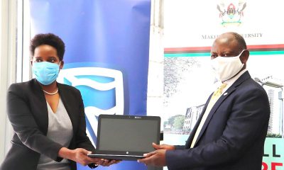 The Vice Chancellor-Prof. Barnabas Nawangwe (R) receives one of the laptops from Stanbic Bank CEO-Anne Juuko (L) during the handover of the donation on 14th October 2020, CTF1, Makerere University, Kampala Uganda.