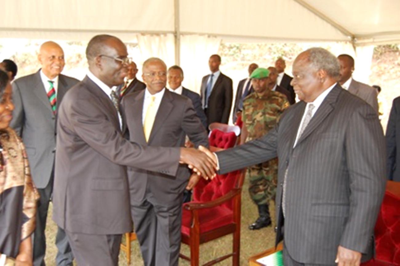 Former President of Kenya and Alumnus, H.E. Dr. Mwai Kibaki (R) shakes hands with Makerere University Anthem Composer Mr. Grace Wilson Mutekanga Igaga after he was honoured for his contribution on 3rd August 2013.