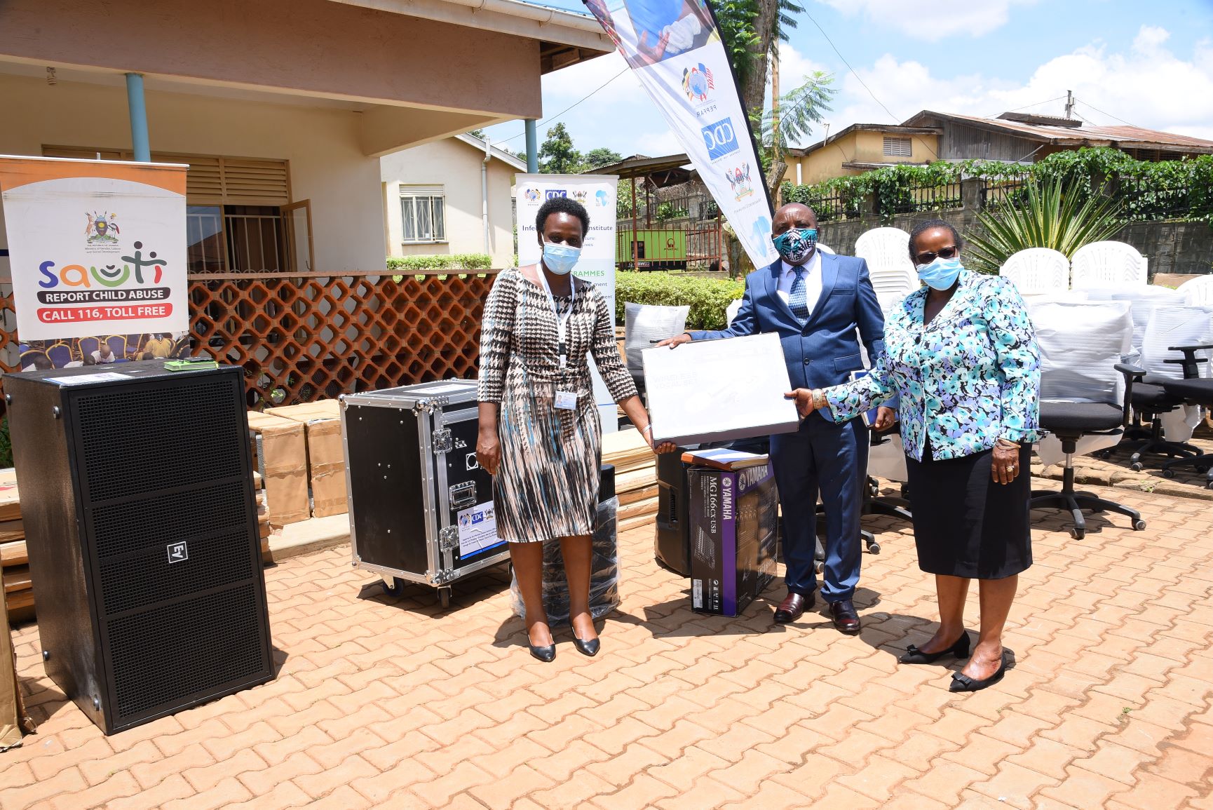 L-R: Dr. Zikulah Namukwaya-IDI hands over the donation to Commissioners, Mr. Fred Ngabirano and Ms. Angella Nakafeero from MGLSD on 27th October 2020, Uganda Child Healthline, Kireka Uganda. Photo credit: IDI/Kazibwe Abubaker
