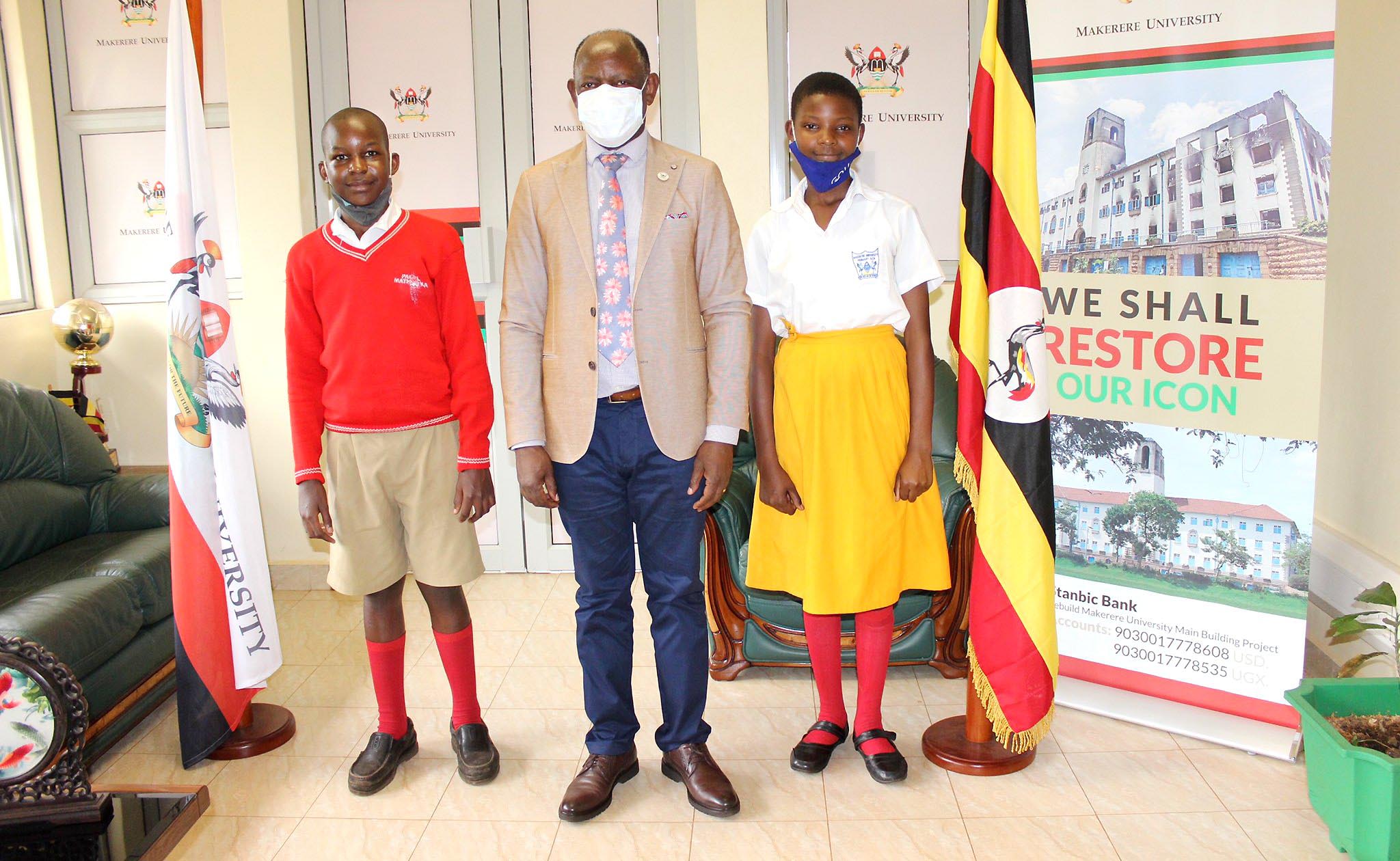 The Vice Chancellor, Prof. Barnabas Nawangwe (C) poses with P.7 pupils of Makerere University Primary School Joan Ayikoru (R) and Daniel Twesigye (L) during the visit on 18th December 2020 at the Central Teaching Facility 1 (CTF1).