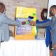 The DVCAA-Dr. Umar Kakumba assisted by CAPSNAC PI-Prof. Samuel Kyamanywa (L) and CAES Deputy Principal-Dr. Gorettie Nabanoga (R) cuts the ribbon to signify the book launch on 4th December 2020, Kampala Uganda.