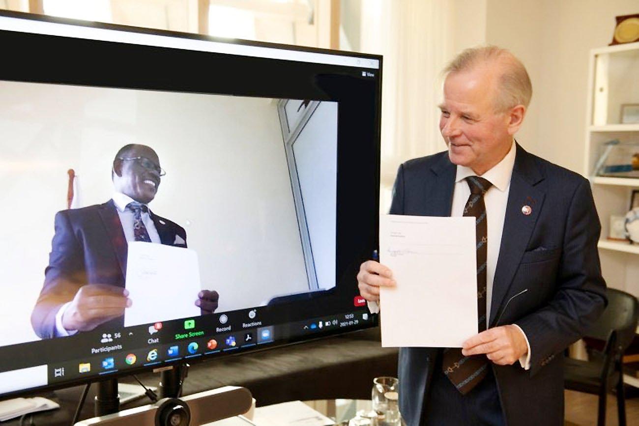 The Vice Chancellor Prof. Barnabas Nawangwe (L) and the President Karolinska Institutet Prof. Ole Petter Ottersen (R) display the MoU signed to establish the Centre of Excellence for Sustainable Health (CESH) after the virtual ceremony on Friday 29th January, 2021.