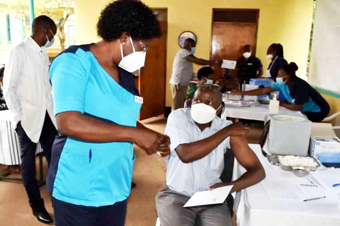 The Principal CAES-Prof. Bernard Bashaasha (R) speaks to a Nursing Officer shortly after receiving his first dose of the AtraZeneca COVID-19 vaccine at the Makerere University Hospital on 31st March 2021.