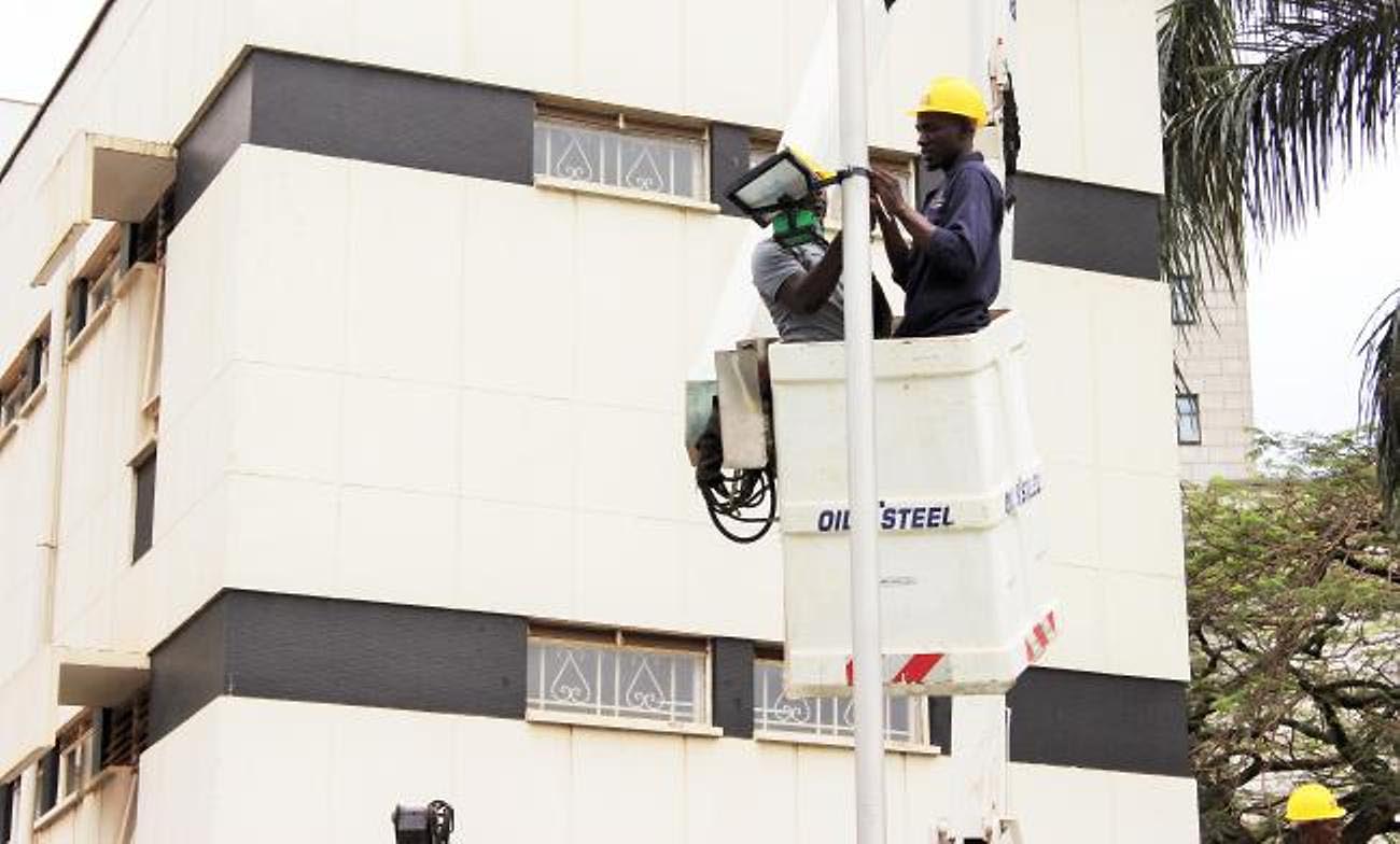 Project researcher, Joel Ssematimba (L) joins the KCCA technical team to deploy an AirQo-Low-cost air pollution monitoring device in Kampala City, Uganda. Image:CoCIS