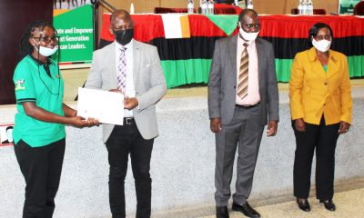 The Vice Chancellor, Prof. Barnabas Nawangwe (2nd L) presents the Award to a female beneficiary as MCFSP Coordinator-Dr. Justine Namaalwa (R) and MCFSP Selection Committee Chairperson-Dr. Muhammad Ntale (2nd R) witness on 12th March 2021, CTF2 Auditorium, Makerere University.