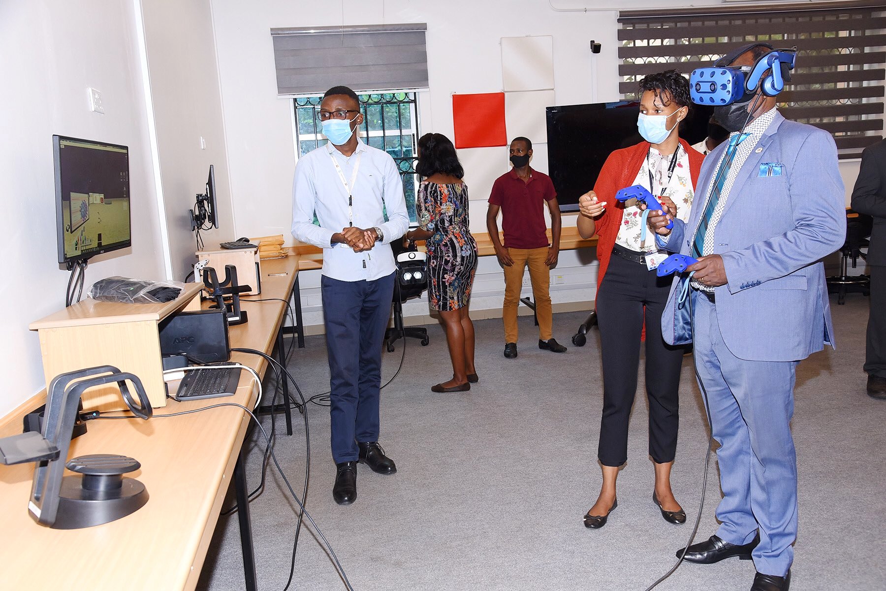 The Vice Chancellor, Prof. Barnabas Nawangwe (R) gets acquainted with Virtual Reality (VR) in the African Center of Excellence in Bioinformatics (ACE), Uganda during the IDI AGM on 15th March 2021, Makerere University, Kampala Uganda, East Africa.