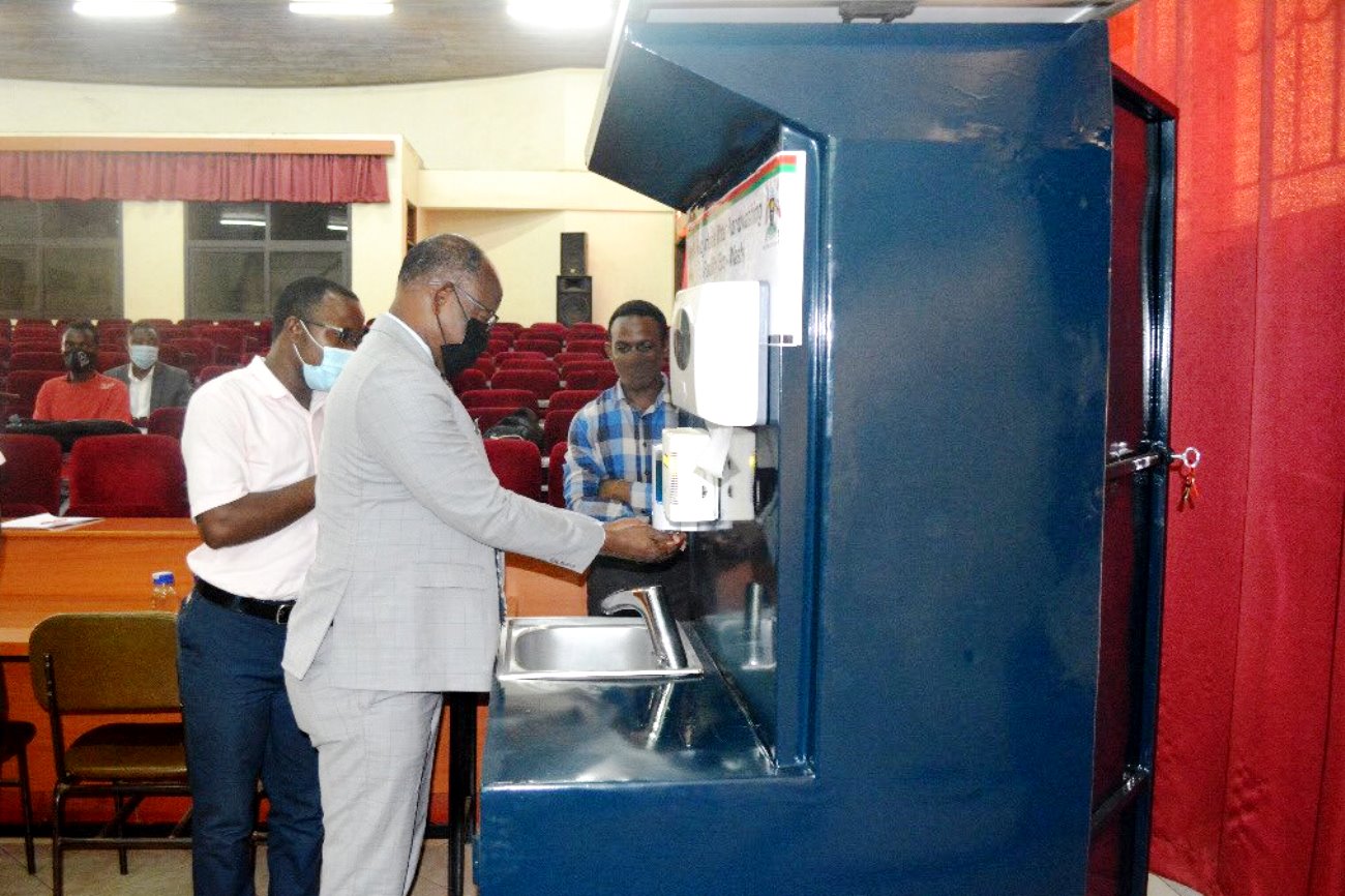 The Vice Chancellor, Prof. Barnabas Nawangwe uses the Mak-RIF-funded Eco Wash Facility during the official launch as Dr. Peter Olupot (L) and his research team witness on 4th March 2021, Conference Hall, CEDAT, Makerere University.