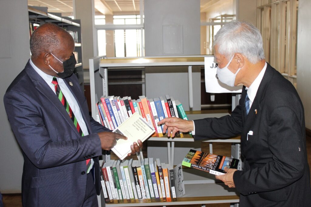 Japanese Ambassador to Uganda-H.E Fukuzawa Hidemoto (R) and the Vice Chancellor-Prof. Barnabas Nawangwe (L) look at some of the titles during the handover of books the University Library on 20th April 2021.