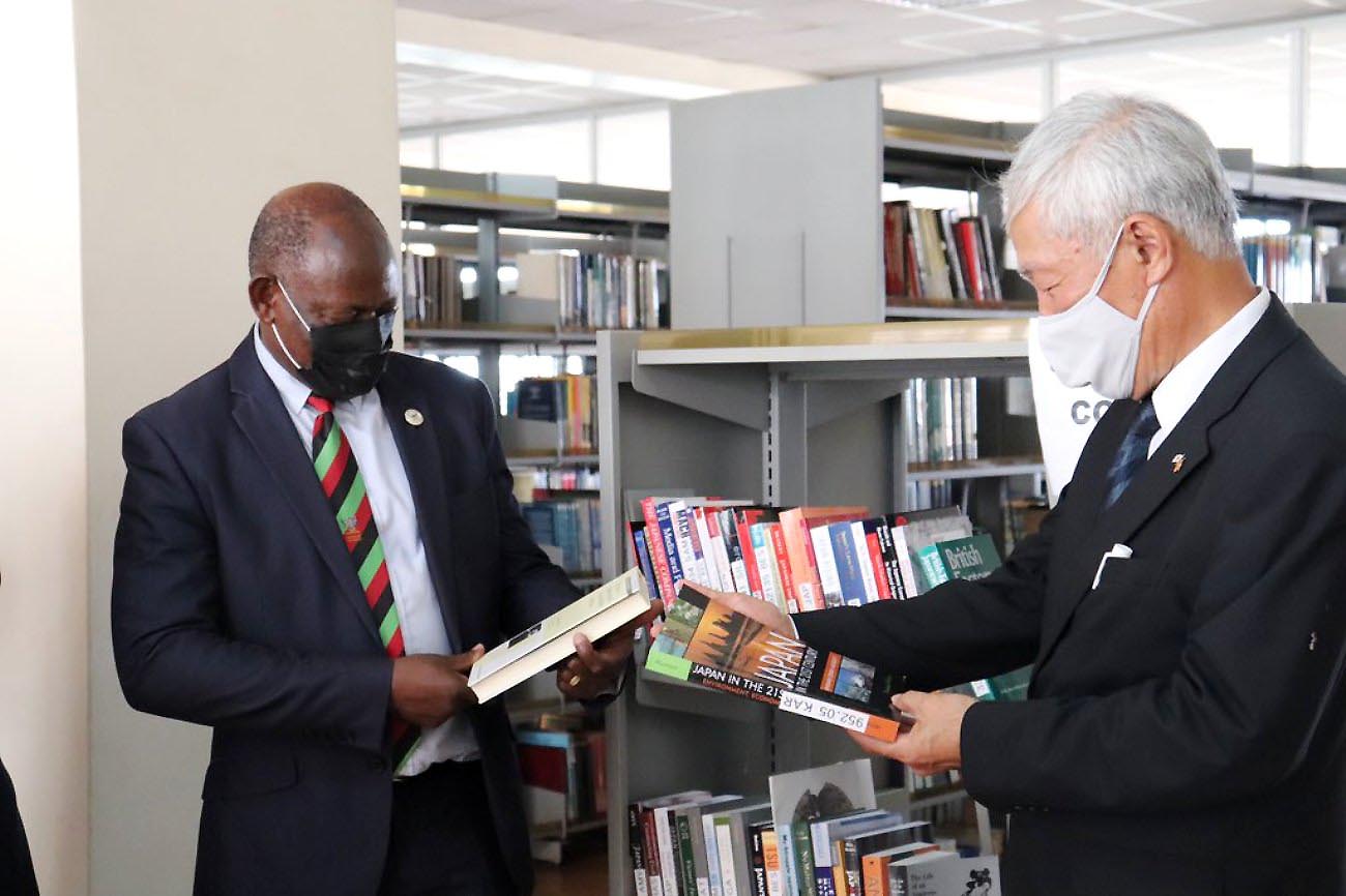 The Japanese Ambassador to Uganda, H.E. Fukuzawa Hidemoto (R) and the Vice Chancellor, Prof. Barnabas Nawangwe (L) admire some of the titles after the donation was handed over on 20th April 2021, Main Library, Makerere University