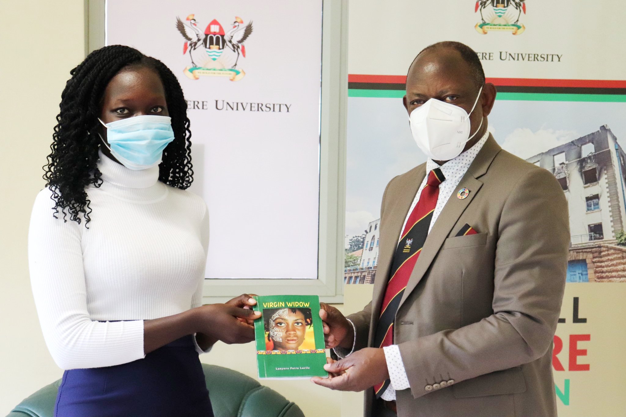 The Vice Chancellor, Prof. Barnabas Nawangwe (R) receives a copy of the book "Virgin Widow" from the author, Makerere University Student, Miss Lanyero Patra Lucile (L) on 13th April 2021, CTF1.