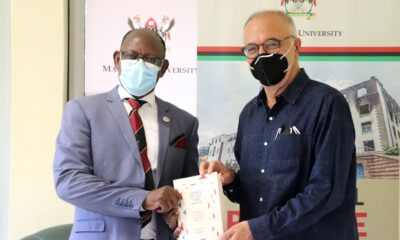 The Vice Chancellor, Prof. Barnabas Nawangwe (L) receives a copy of the book - Neither Settler nor Native: The Making and Unmaking of Permanent Minorities - from Prof. Mahmood Mamdani (R) on 1st April 2021, CTF1, Makerere University.